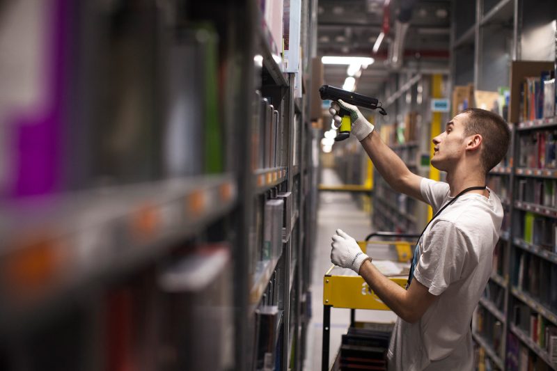An employee uses a scanner to restock items on shelves in a picking tower at the Amazon.com Inc. fulfillment center in Poznan, Poland, on Friday, June 12, 2015. Amazon is the largest distributor of e-books in Europe, where the product's popularity has experienced a surge in recent years. Photographer: Bartek Sadowski/Bloomberg